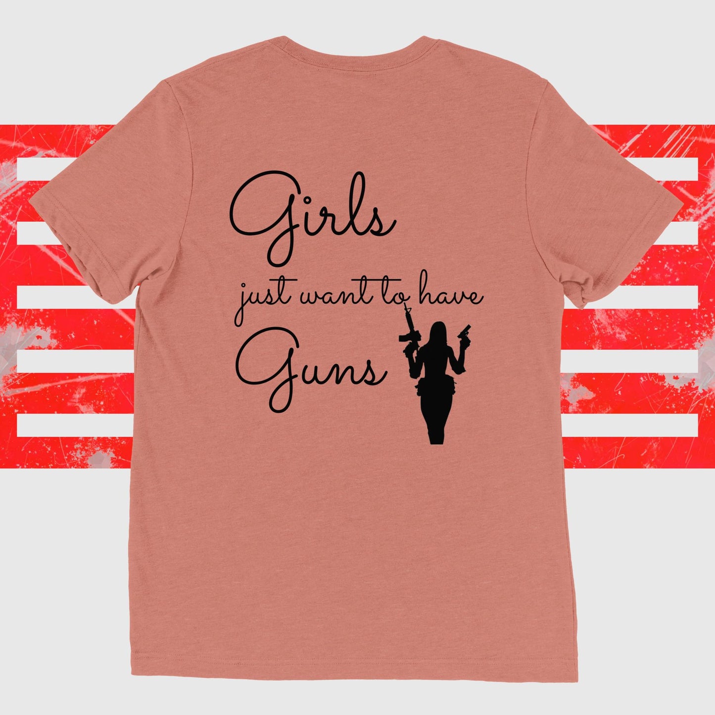 Peach women's tee with "Girls Just Want To Have Guns" text, featuring silhouette of a woman holding guns against red and white striped background.